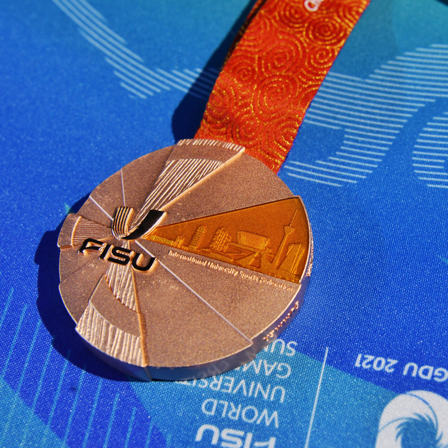 大运会奖牌-银牌设计师黄乔逸介绍,奖牌正面设计赋予"太阳神鸟"羽翼