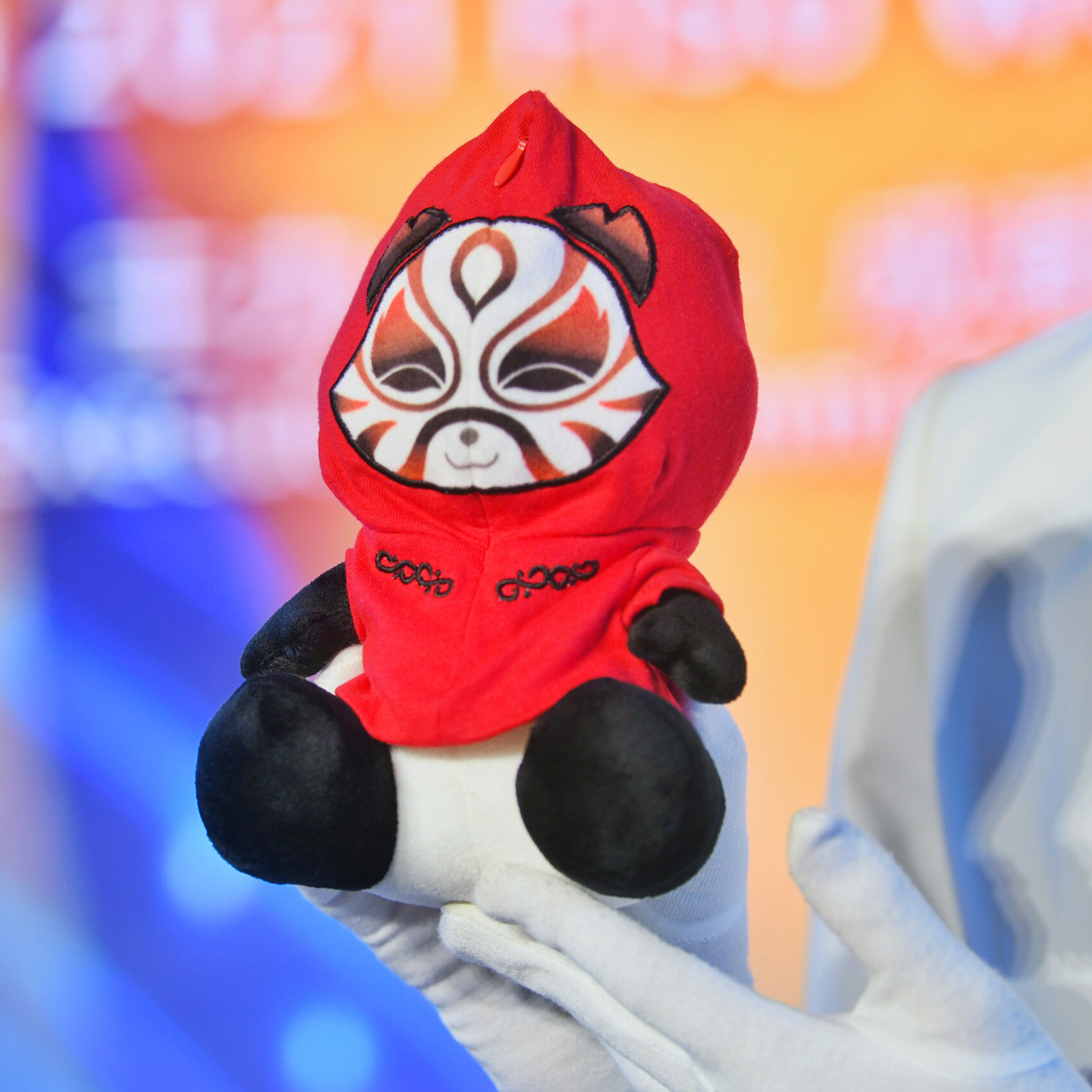大赛吉祥物"蓉宝"身穿红色拉链式运动帽衫,将帽衫拉链拉合后,头部便